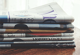 stack of newspapers on a wooden table 