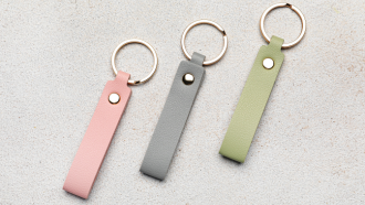 photo of three leather key chains in pink, gray, and green. 