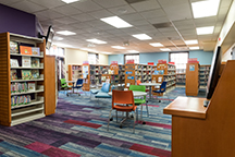 Newly renovated Juvenile area of the Children's Department of the Main Library. Includes several tables with chairs and bookshelves full of books.  